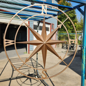 Custom metal compass design with directional points finished in powder coating
